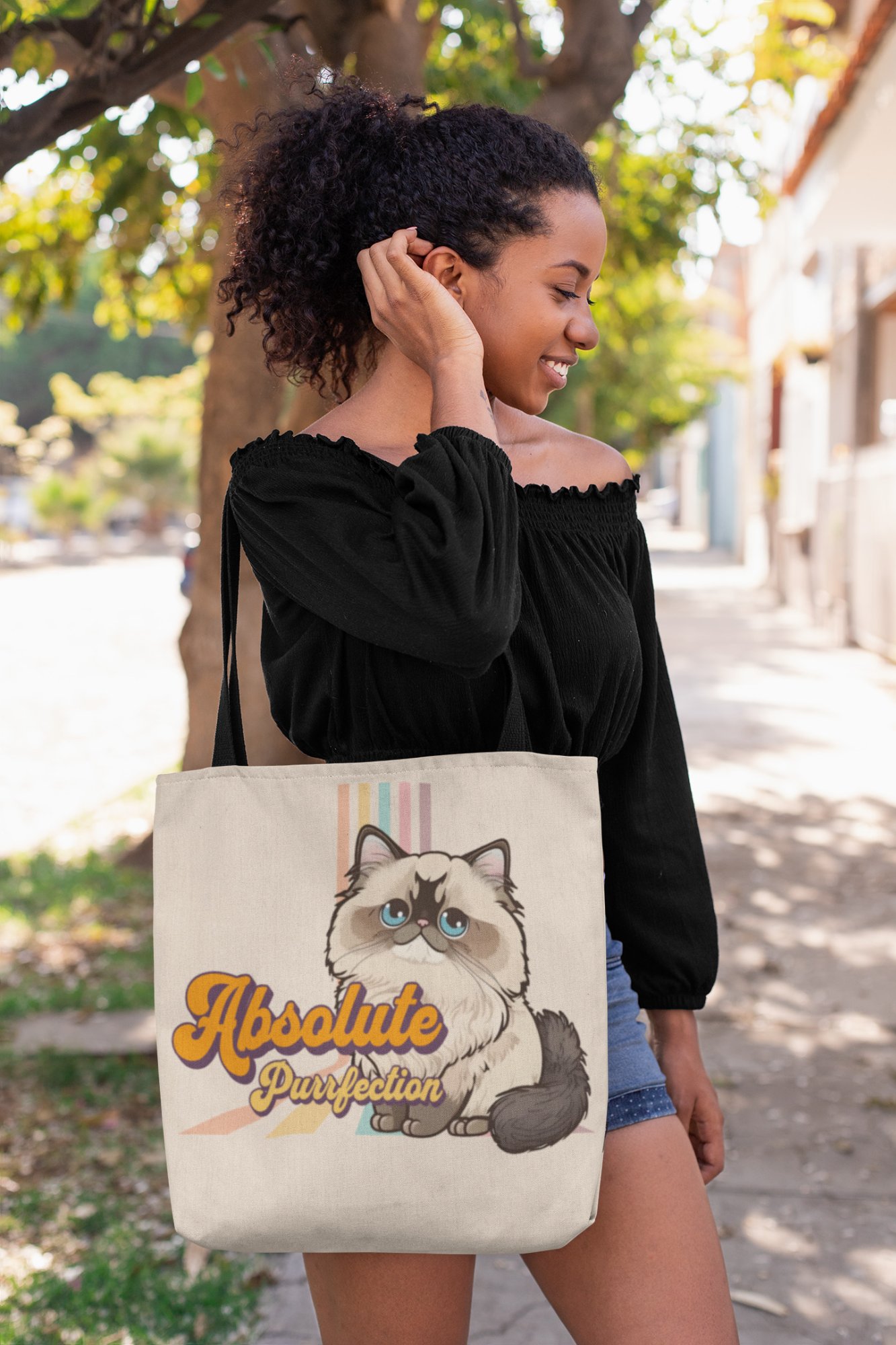 Woman carrying the Himalayan Cat Absolute Purrfection tote bag outdoors